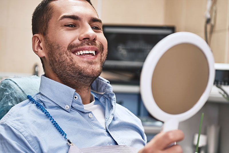 person smiling brightly after their dental treatment within the Magnolia Ridge Dentistry