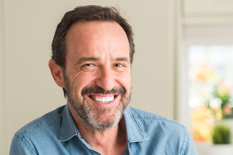 Handsome middle age man with a happy face standing and smiling with a confident smile showing teeth