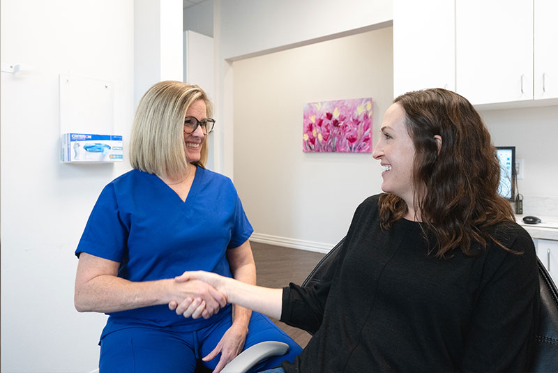 team member shaking patients hand after dental implant consultation