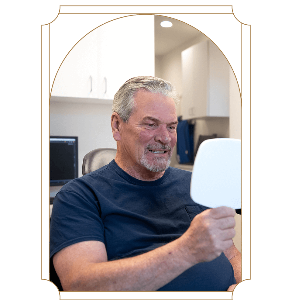 dental implant patient smiling in mirror